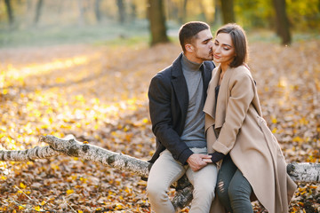 lovely couple wsitting in the park during autumn