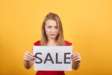 young blonde girl in red t-shirt over isolated orange background shows emotions