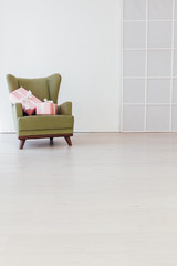 green vintage chair in the interior of an empty white room