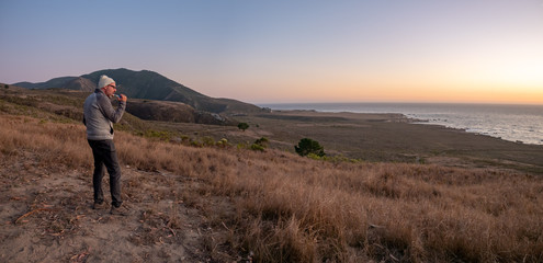 Camper brushing teeth on bluff over ocean at Montana de Oro State Park, Los Osos, California, USA