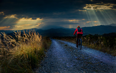 Cycling woman riding on bike in autumn mountains forest landscape. Woman cycling MTB gravel road trail track. Outdoor sport activity.