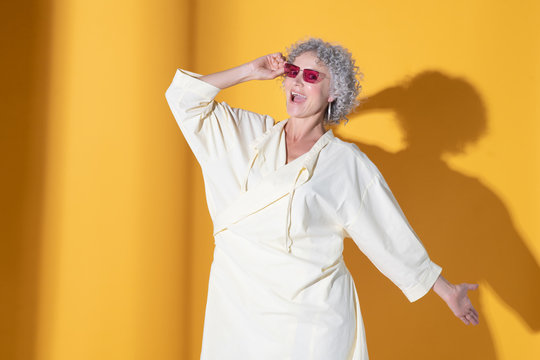 Curly Woman. Curly Mature Woman Wearing Long Baggy Dress And Bright Sunglasses