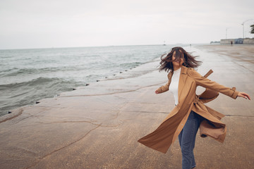 young girl walking on the beach during autumn