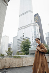 woman walks the streets of Chicago in a brown cloak