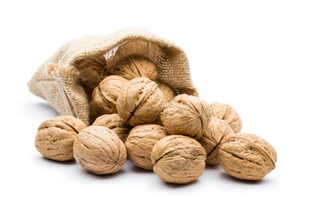 pile of walnuts in juta bag on white background