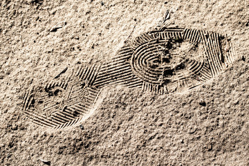 Footprint from shoes in green sand, background texture of the earth.