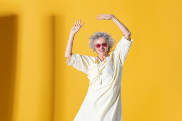 Mature curly woman in bright glasses moving and posing