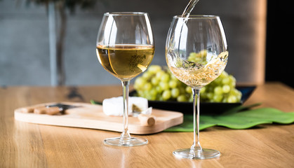 Waiter pouring white wine into wineglass. 