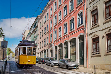 Fototapeta na wymiar Tourist yellow tram rides down the slopes at Bairro Alto neighborhood, Lisbon, Portugal