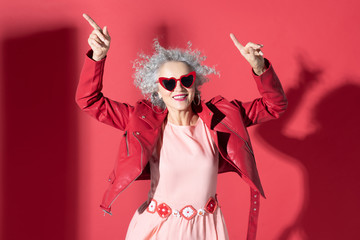 Woman in pink dress and red jacket moving and laughing