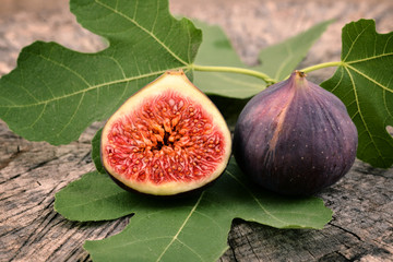 Fresh figs on old wooden background. Fruit - fig with leaves. 