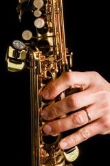 Obraz premium soprano saxophone in hands on a black background