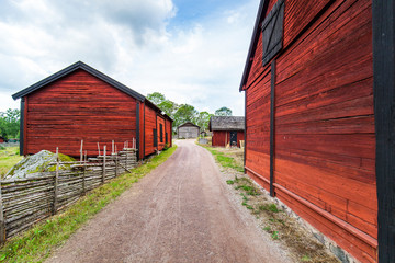 Schwedischer Bauernhof mit roten Holzhäusern. Scandinavian farmhouses on countryside. Red old wooden farm houses.