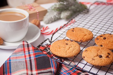 Cup of tea, homemade cookie, Christmas gift boxes and Christmas decor on the green background.