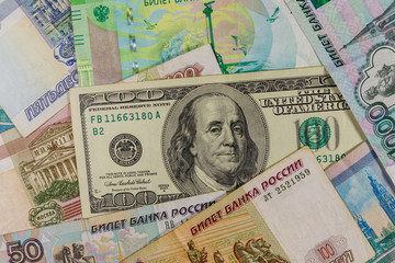Fototapeta na wymiar One hundred dollar bill on a background of russian rubles banknotes