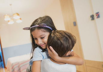 Brothers hugging in the bedroom of their house
