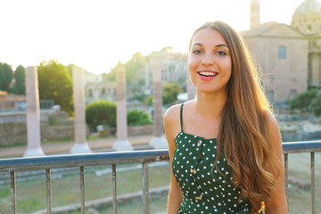 Beautiful young tourist girl visiting the Roman Forum in Rome, Italy at sunset.