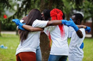 Group of happy african volunteers hugs in park. Africa volunteering, charity, people and ecology...