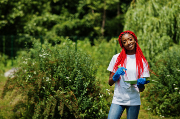 African red haired volunteer woman with clipboard in park. Africa volunteering, charity, people and...