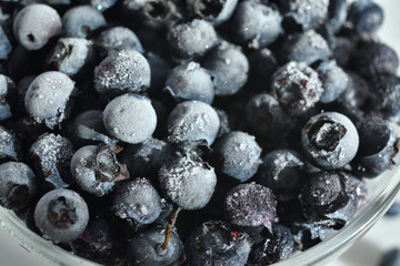 frozen Blueberry background. close up with selective focus and Frost. Fresh blueberry with drops of water on white background. Concept of healthy and dieting eating