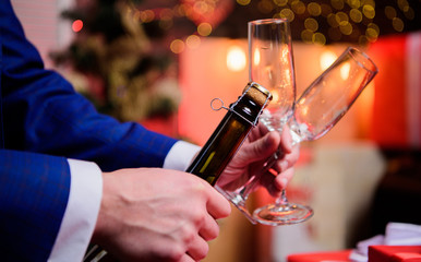 Toast and cheers concept. Male hands opening champagne bottle on christmas decorations background. Lets celebrate. Open champagne and celebrate holiday. Celebrate new year with champagne drink
