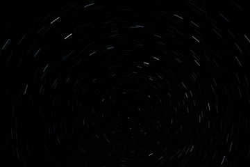 Long exposure photo of Northern hemisphere night sky movement. Stars light trails. Space exploration concept.