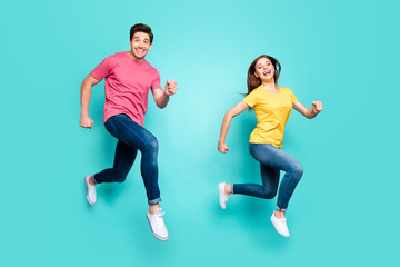 Fototapeta na wymiar Full length body size profile side view of nice attractive sporty cheerful cheery glad couple running fast in air having fun holiday isolated over bright vivid shine vibrant green turquoise background