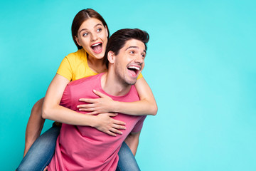 Obraz premium Portrait of his he her she nice attractive lovely excited glad cheerful cheery couple guy piggy-backing girl having fun isolated over bright vivid shine vibrant green turquoise background