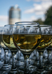 Close up view of glasses filled with champagne and business building in the background