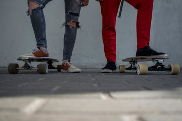Two male skaters standing side by side with their skateboards on the ground low angle view