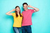 Portrait of his he her she nice attractive lovely funny cheerful cheery couple hugging showing v-sign near eye lifestyle isolated over bright vivid shine vibrant green turquoise background