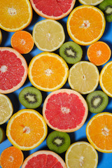 Fresh summer fruits on background. Healthy food concept. Flat lay. Tropical summer mix grapefruit, orange, mandarin, kiwi, lemon