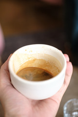 cup with black coffee in hand