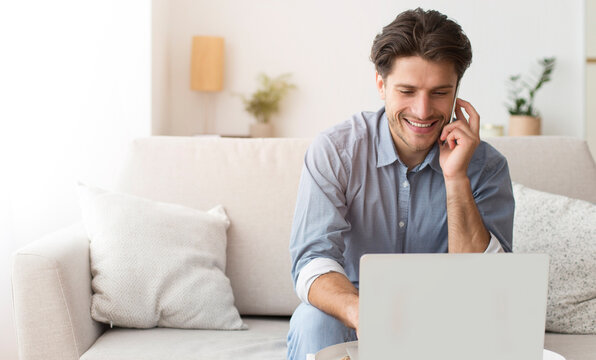 Cheerful Entrepreneur Talking On Phone Using Laptop At Home