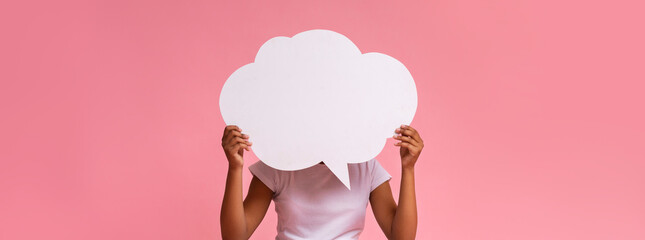 Black girl holding an empty speech bubble on pink background