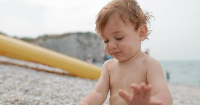 little boy plays with mom on the beach . Shot on Canon 1DX mark2 4K camera