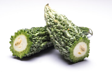 Bitter gourd cut in halves on isolated white background