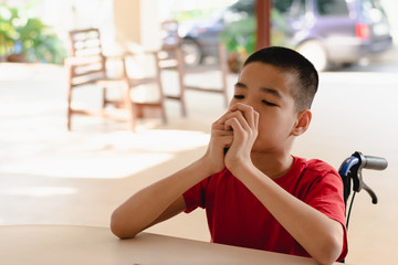 Asian disabled child on wheelchair eating snacks by themselves,The skills to practice muscle development,Special children's lifestyle,Life in the education age,Happy disability kid concept.