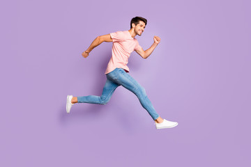 Fototapeta na wymiar Full length body size view of his he nice attractive lovely sportive cheerful cheery glad guy wearing pink tshirt jumping running isolated on violet purple lilac pastel color background