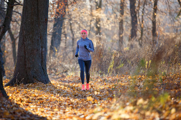 Fototapeta premium Young fitness woman running in the park