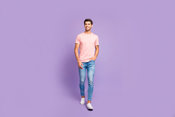 Full length body size view of his he nice attractive cheerful cheery content guy wearing pink tshirt strolling walking isolated on violet purple lilac pastel color background