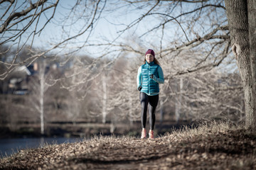 Young woman running training in autumn park
