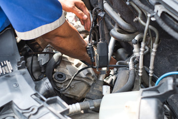 Fototapeta na wymiar Close up of mechanic arm and hand fixing inside car engine room front hood open.