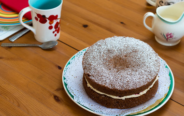 cup of coffee and cake on wooden table for afternoon tea. April 2019.