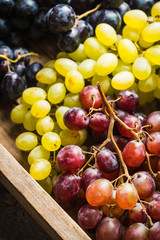 Ripe different sorts of grape on the rustic background. Selective focus. Shallow depth of field.