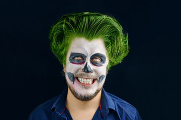 Masked man of the day of death on Halloween. rolled his eyes, smiles slyly, disheveled green hair
