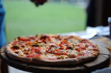 Pizza with olives on a wooden plate