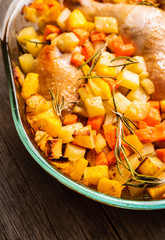 Autumn foodie, roasted chicken with pumpkin, carrots, potatoes and spices in glass pan. Selective focus. Shallow depth of fied.