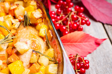 Autumn foodie, roasted chicken with pumpkin, carrots, potatoes and spices in glass pan. Selective focus. Shallow depth of fied.