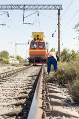 workers replace old wires with new ones in the railway using equipment